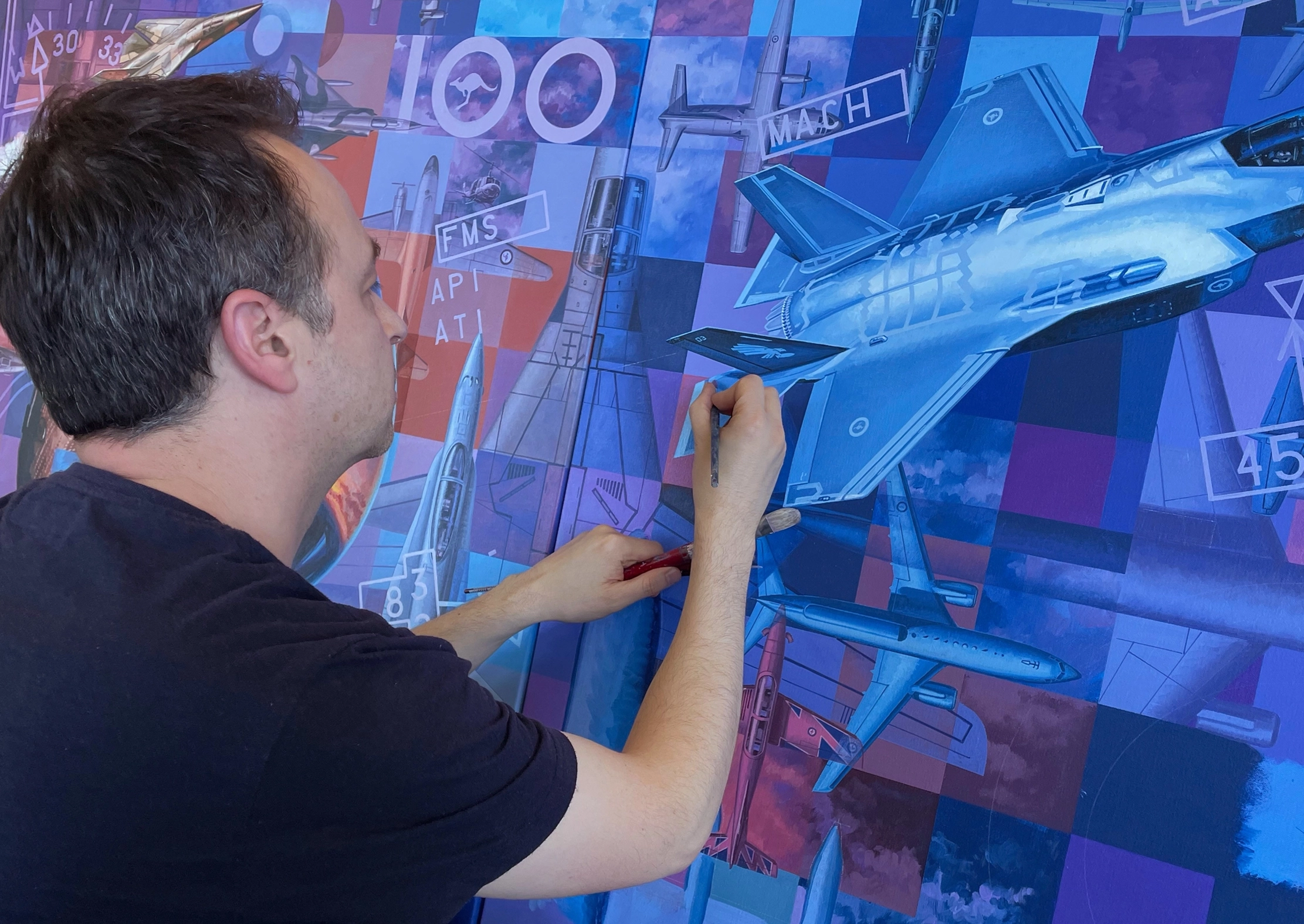 Drew Harrison painting the Last panel of the Then. Now. Always. Artwork